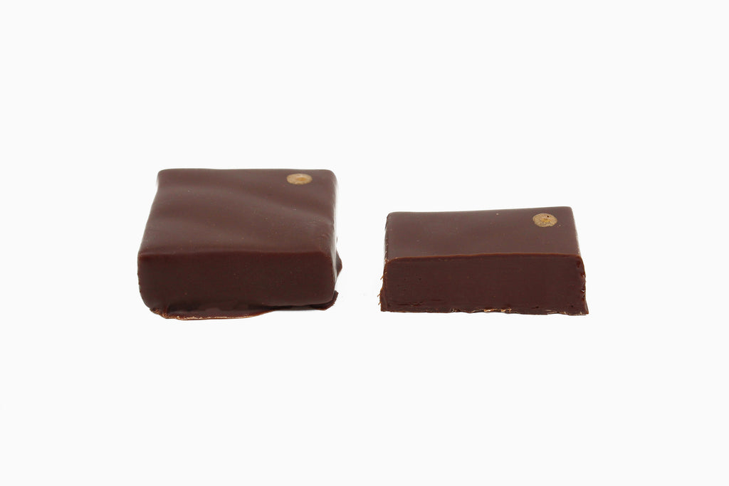 Two chocolate squares with a gold dot on the upper right corner. Black walnut and coffee flavor