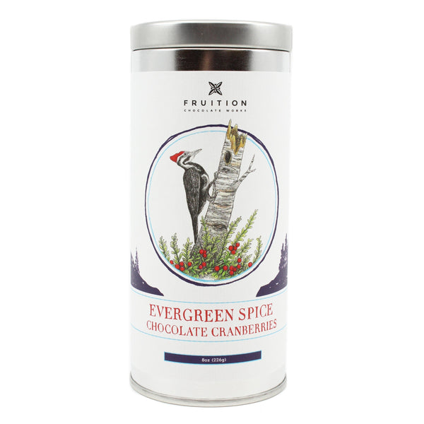 Metal tin with a white label featuring a woodpecker on a tree. Label reads "evergreen spice chocolate cranberries"