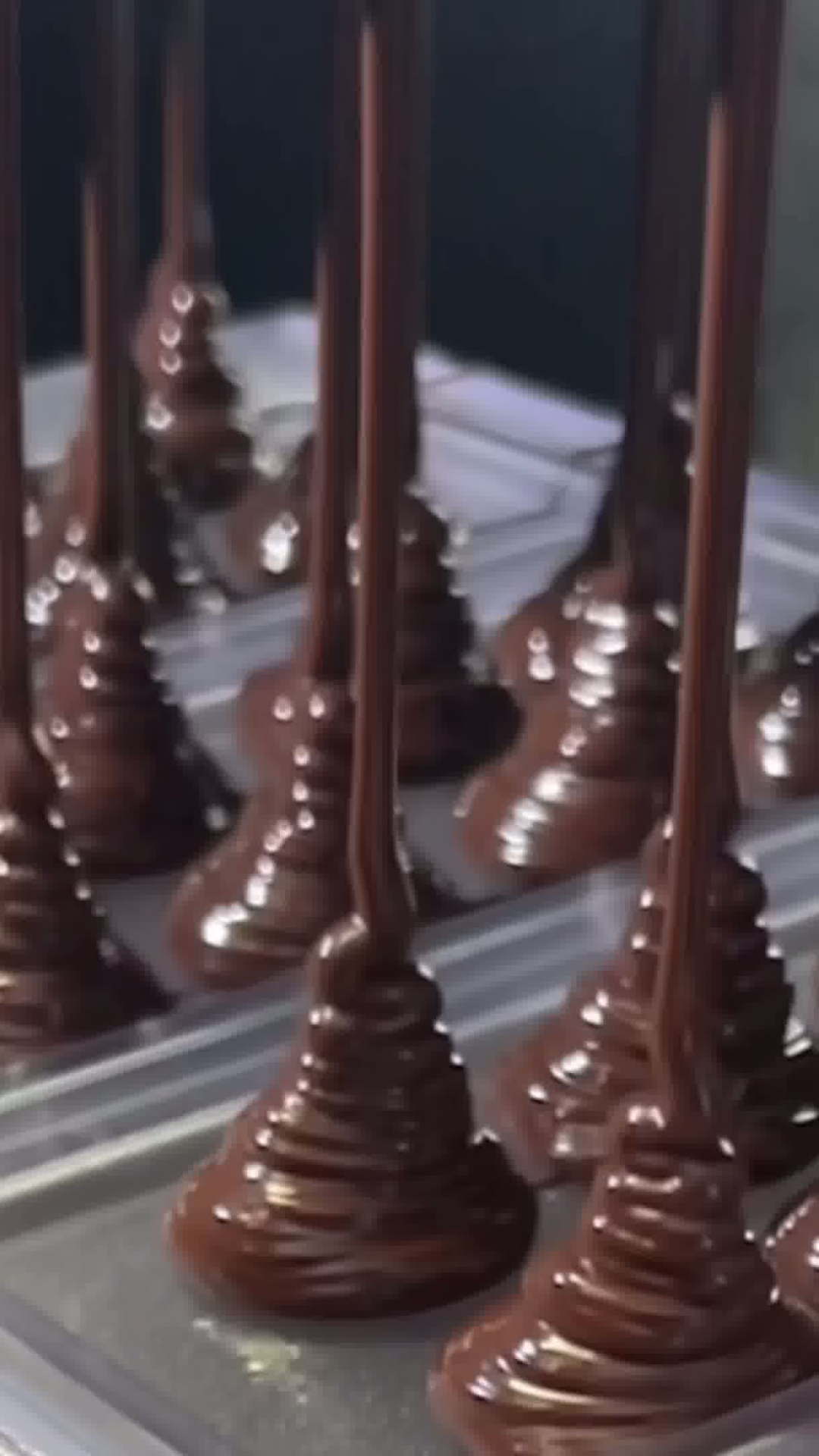 Chocolate-dipped cones on a reflective surface